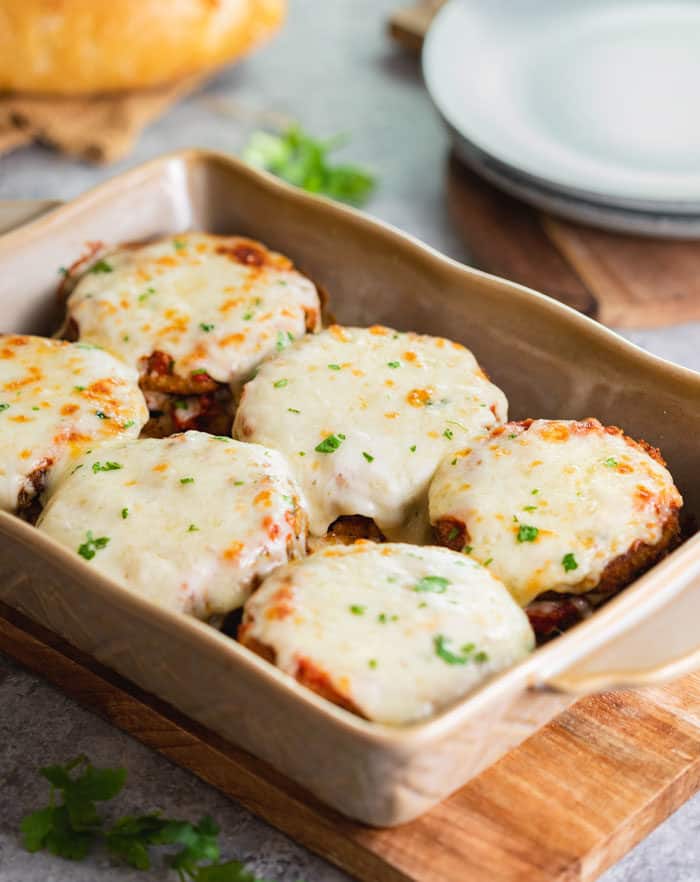 A casserole dish filled with warm eggplant Parmesan hot out of the oven.