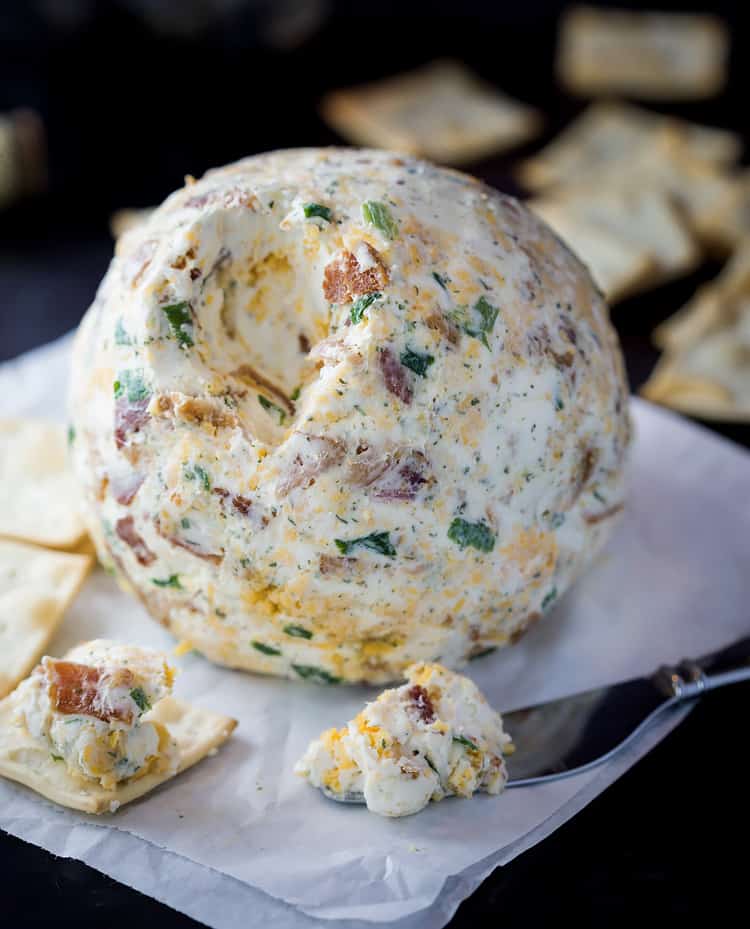 A bacon ranch cheese ball on surrounded by crackers.