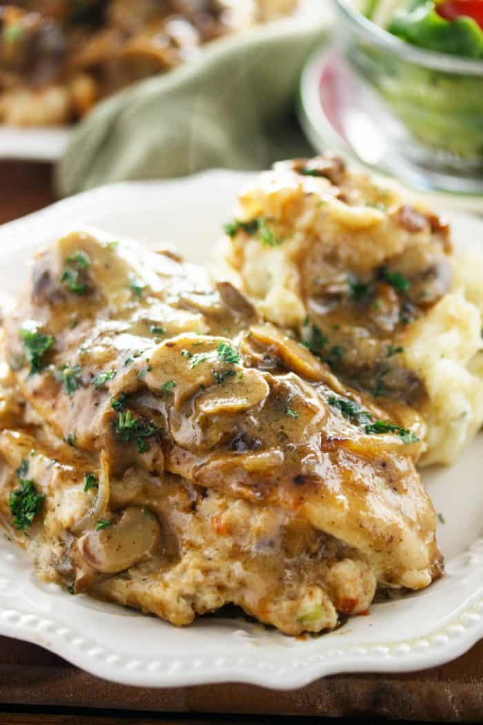 close up view of stuffed chicken marsala topped with a marsala mushroom sauce and fresh parsley.