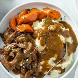 A labeled image of Mississippi Pot Roast on a white plate on a marble surface.