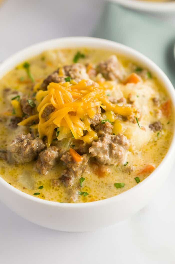 Close up of Crock Pot Cheeseburger Soup with grated cheese on top.