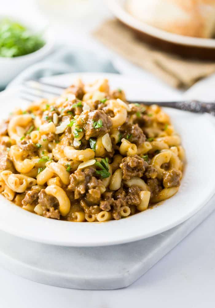 Homemade Hamburger Helper in a white bowl with a fork in the background.