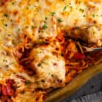 A casserole dish filled with baked spaghetti with mozzarella cheese.