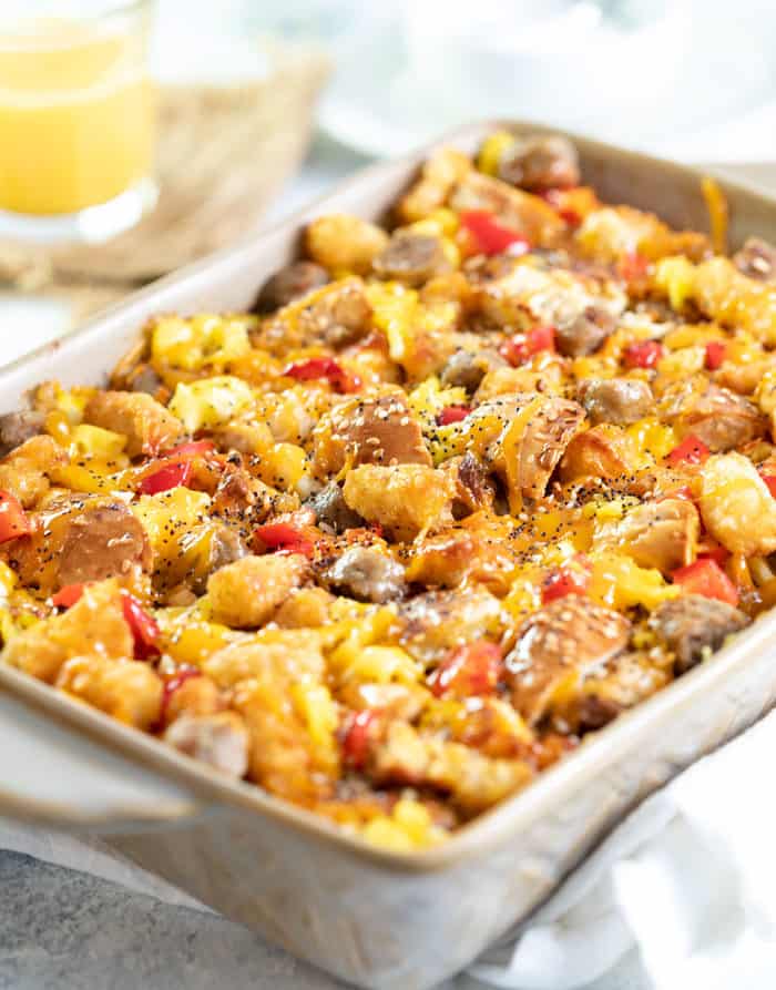 Overnight everything bagel casserole in a casserole dish with a glass of orange juice in the background.