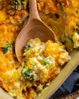 broccoli chicken rice casserole in a casserole dish with a wooden spoon.