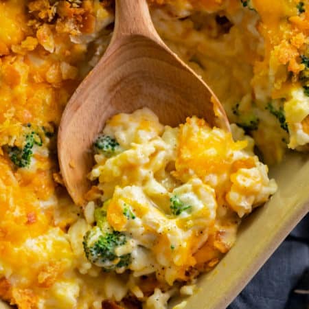 broccoli chicken rice casserole in a casserole dish with a wooden spoon.