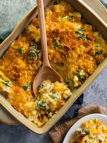 Chicken Broccoli Rice Casserole in a brown baking dish with a wooden spoon in it.