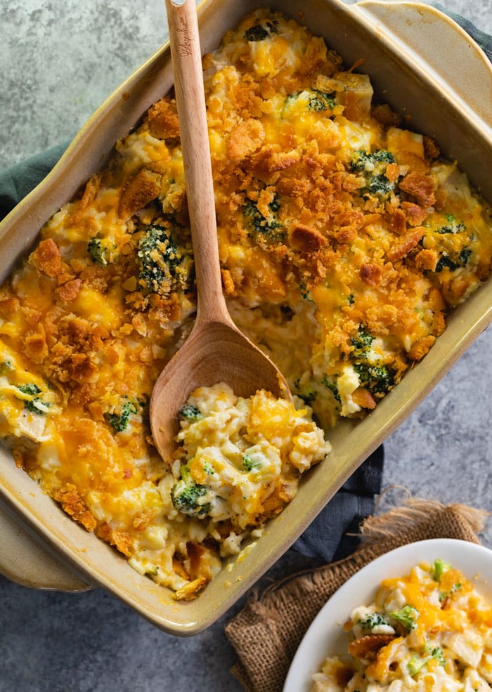 Chicken Broccoli Rice Casserole in a brown baking dish with a wooden spoon in it.