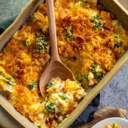 Chicken Broccoli Rice Casserole in a brown casserole dish with a spoon scooping some up.