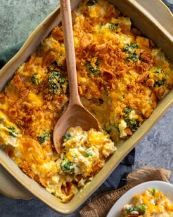 Chicken Broccoli Rice Casserole in a brown casserole dish with a spoon scooping some up.