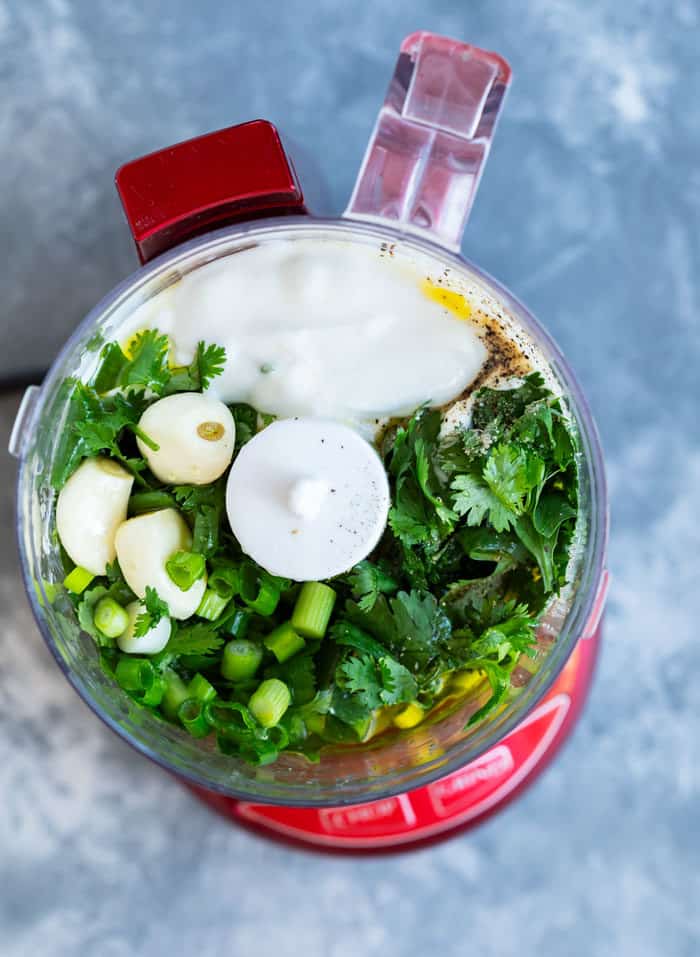 food processor filled with ingredients needed to make cilantro lime dressing
