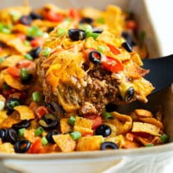 Taco casserole being scooped up from a casserole dish.