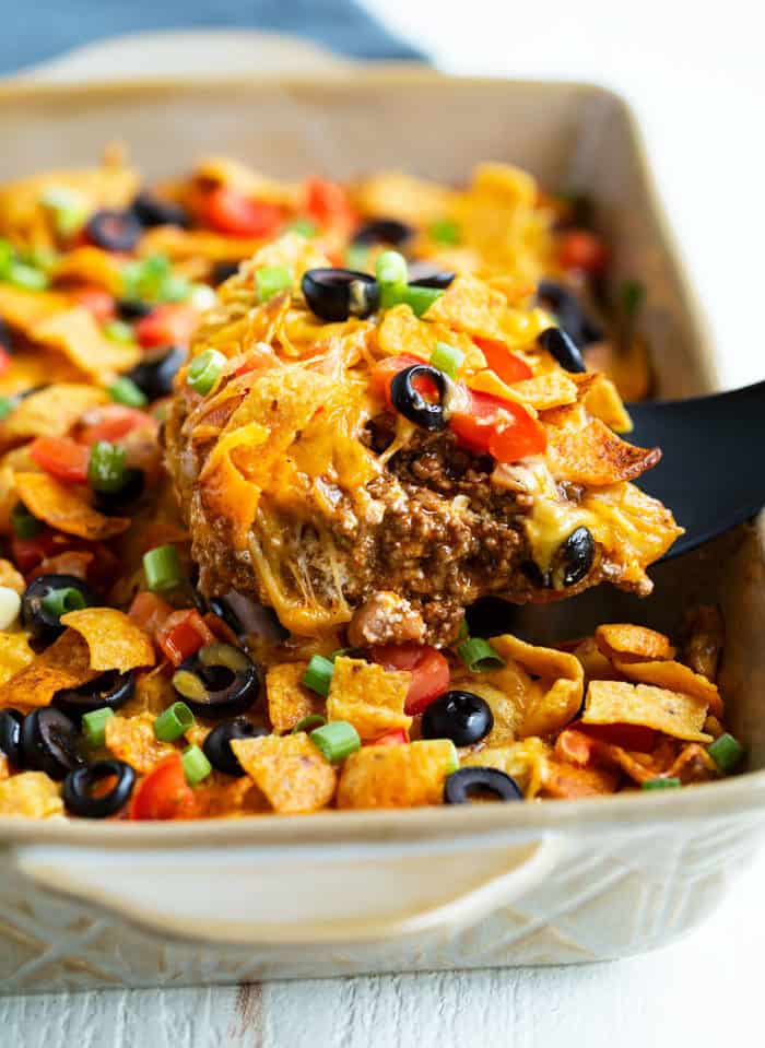 Taco Casserole being scooped out of a casserole dish with a spatula.