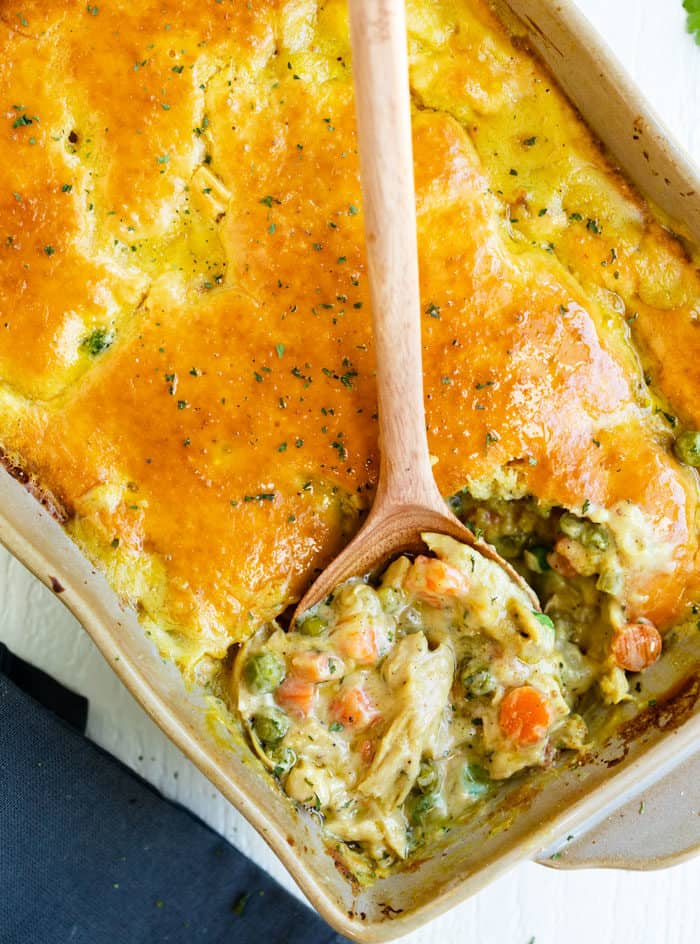 Chicken Pot Pie Casserole with a wooden spoon in a casserole dish.