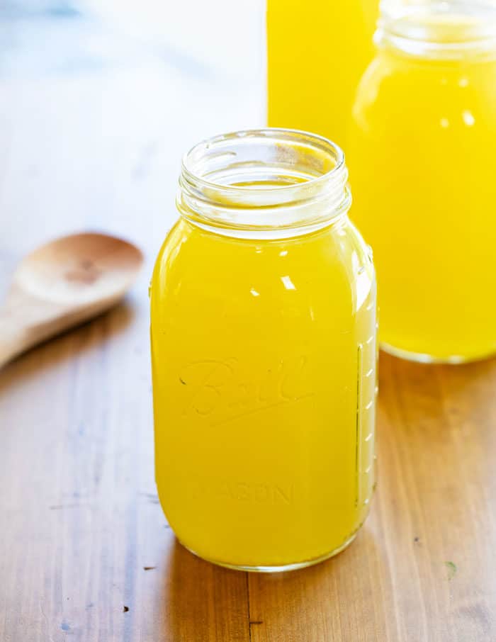 Quarts of canning jars filled with Homemade chicken stock.