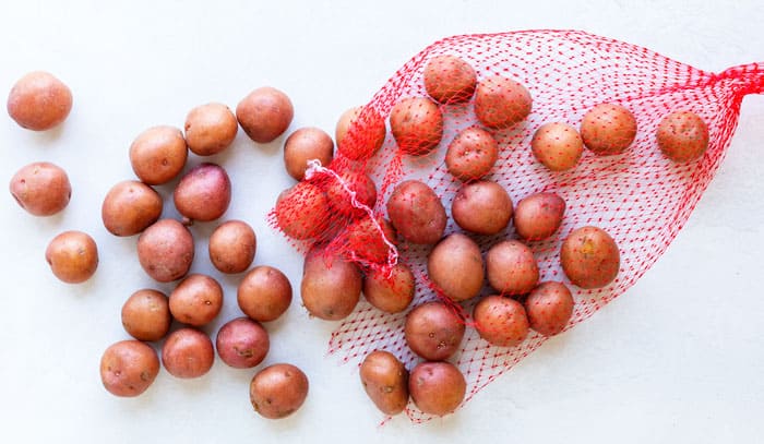 A mesh bag filled with red potatoes