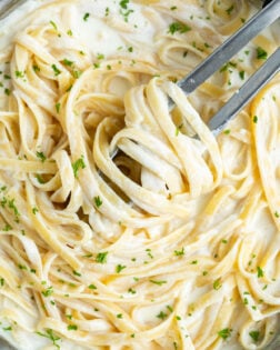 Fettuccine tossed in homemade Olive Garden Alfredo Sauce with fresh parsley on top.