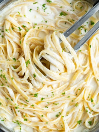 Fettuccine tossed in homemade Olive Garden Alfredo Sauce with fresh parsley on top.
