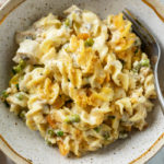 Tuna Noodle Casserole with Creamy egg noodles and peas in a bowl with a fork.