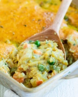 Bisquick Chicken pot pie in a casserole dish with a wooden spoon scooping it up.