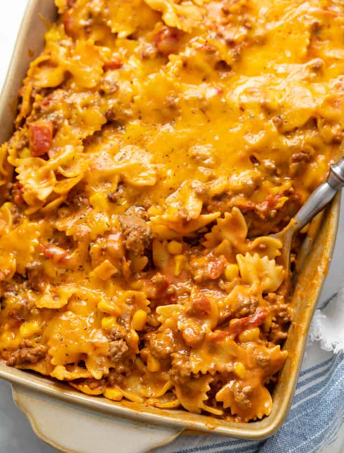 Sloppy joe casserole in a casserole dish with a spoon scooping it up.