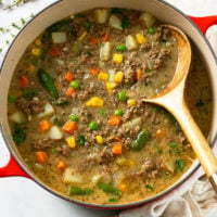 A pot of hamburger soup with ground beef and vegetables.
