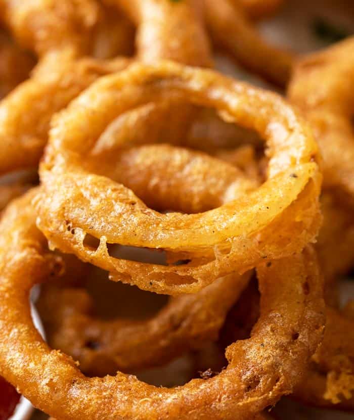 A close up view of a crispy beer batter fried onion ring.