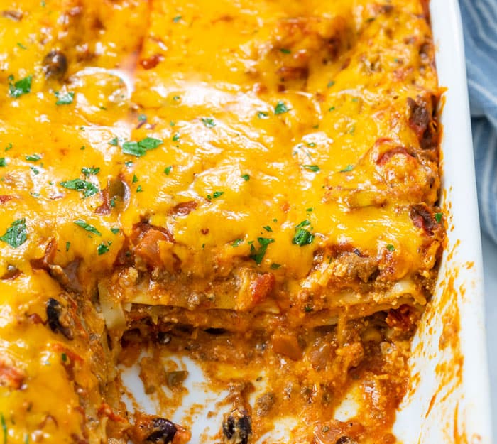 A casserole dish filled with cheesy taco lasagna.