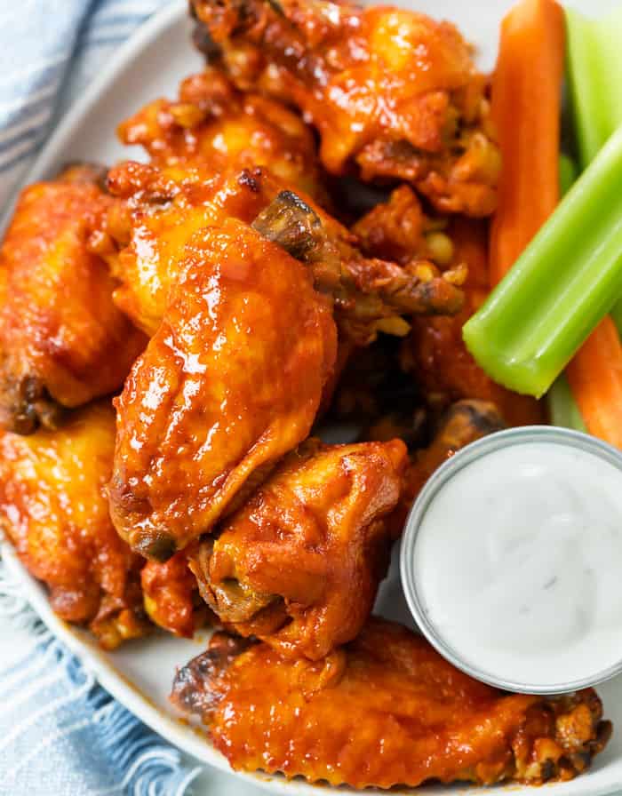 A plate of Crock Pot Buffalo Chicken Wings with Blue Cheese, Celery, and Carrot Sticks.