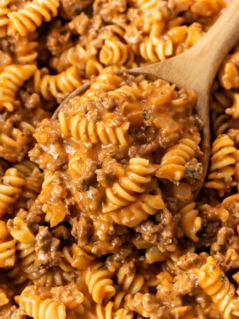 A wooden spoon full of creamy Ground Beef Pasta with Rotini noodles.
