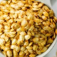 Roasted Pumpkin seeds in a white bowl.