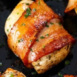 A labeled image of bacon wrapped chicken topped with chopped parsley.