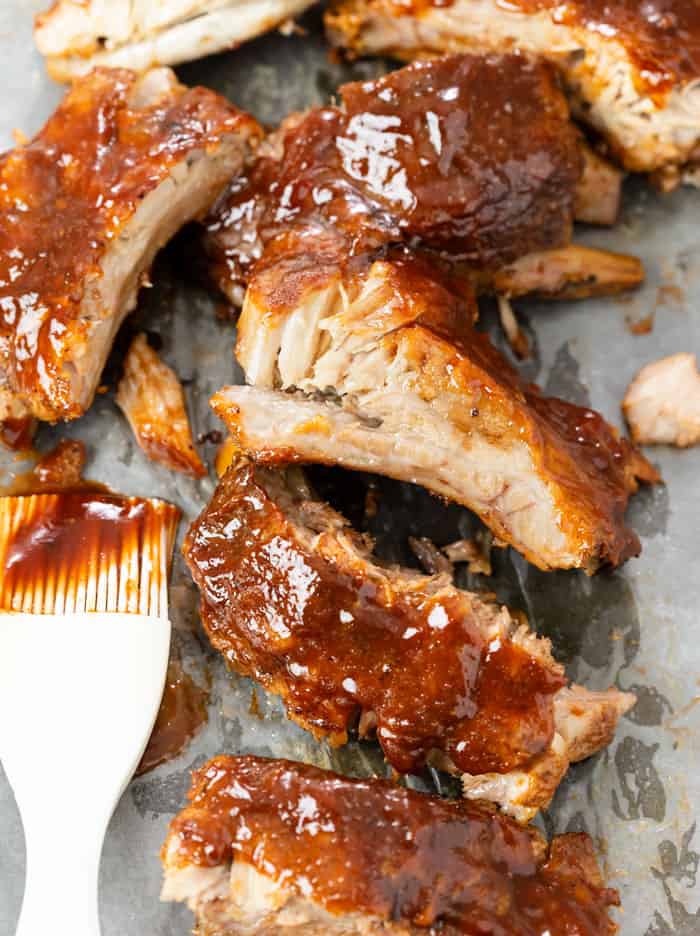 Slow Cooker Ribs next to a pastry brush covered with BBQ Sauce.