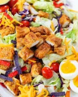 Crispy Chicken Salad with breaded chicken strips, lettuce, tomatoes, hard boiled eggs, cheese, and crispy tortilla crisps.