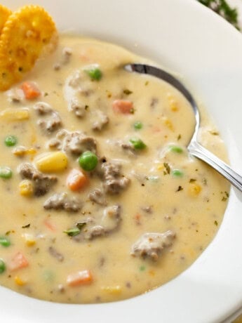 A spoon in a white bowl full of creamy Shepherd's Pie Soup.