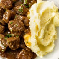 Beef Tips and Gravy on a plate with creamy mashed potatoes.