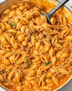 A skillet filled with Creamy Beef and Shells topped with fresh parsley.