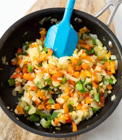 A skillet with finely diced sauteed vegetables to make Turkey Meatloaf.