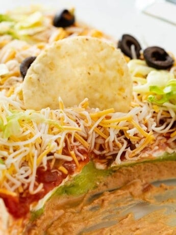 7 layer dip with a tortilla chip in it.