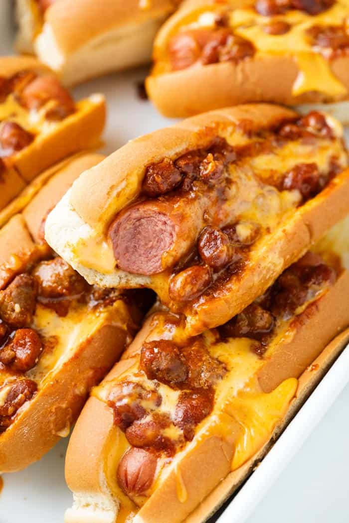 A chili cheese dog with a bite taken out of it.