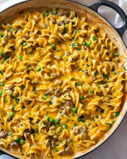 A pot full of Ground Beef Stroganoff topped with Cheese and parsley.