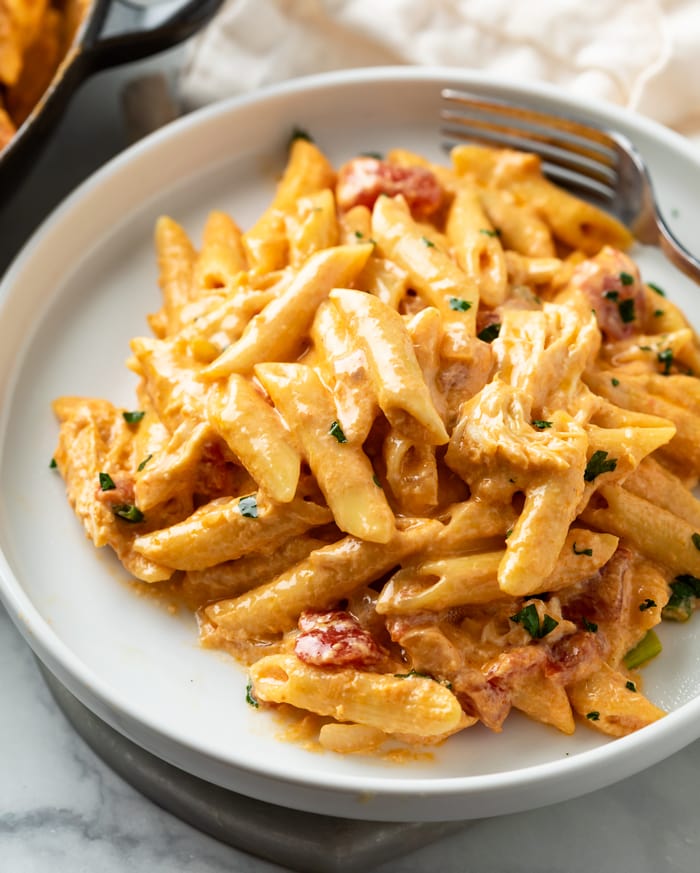 A white plate topped with creamy Buffalo Chicken Pasta with a fork in the background.