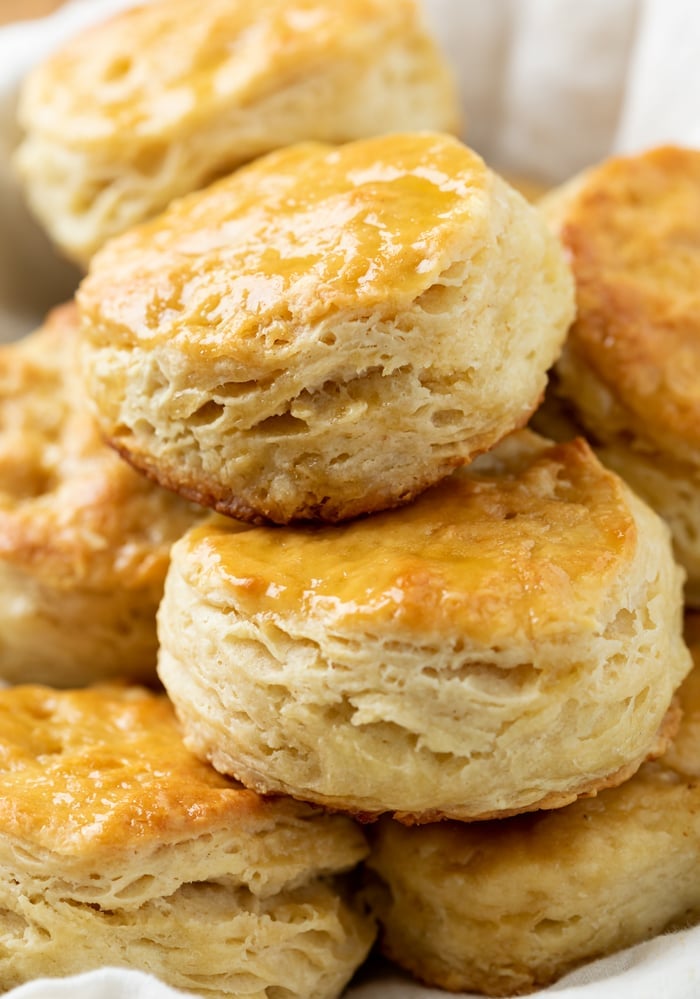 Fluffy Buttermilk Biscuits stacked on top of each other in a bowl.