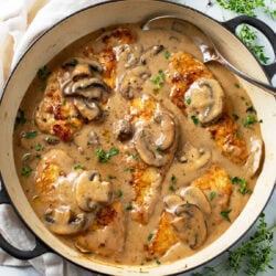 Mushroom Chicken in a skillet with sauce, mushrooms, and thyme.