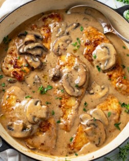 Mushroom Chicken in a skillet with sauce, mushrooms, and thyme.