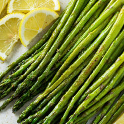 A labeled image of Roasted Asparagus on a plate with lemon slices.
