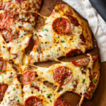 Pepperoni Zucchini Pizza on a pizza stone.