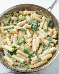 A silver skillet filled with Creamy Broccoli Pasta in a Garlic Parmesan Sauce.