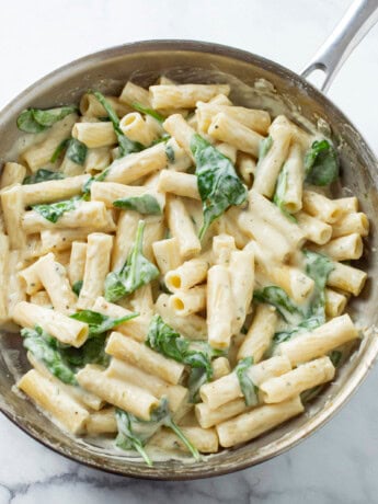 A silver skillet filled with Creamy Broccoli Pasta in a Garlic Parmesan Sauce.