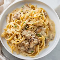 Creamy Mushroom Pasta on a white plate with Parmesan cheese and parsley on top.